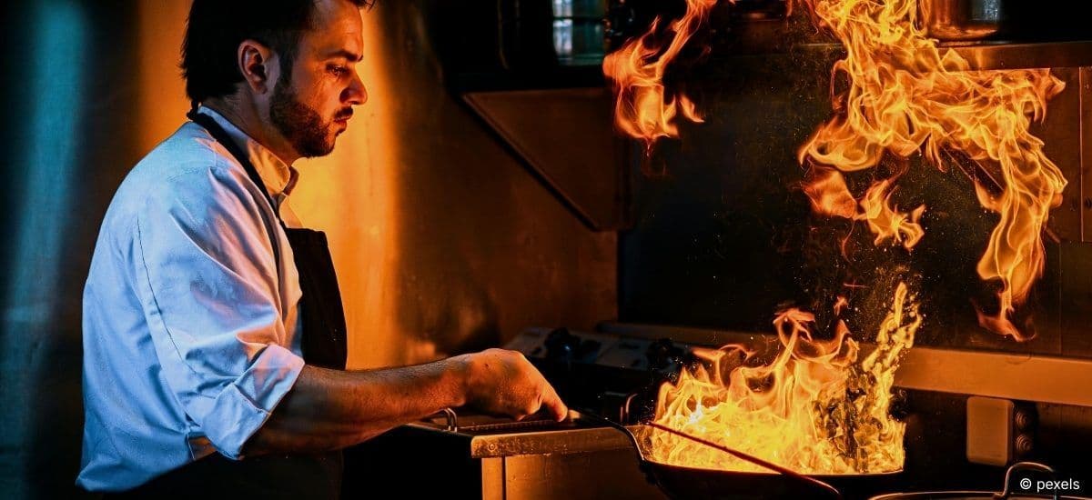 a flame shines bright in the kitchen of a restaurant