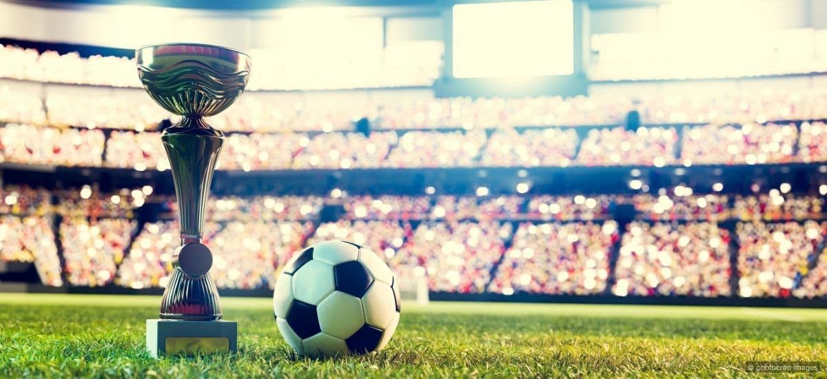 trophy and soccer ball on the world cup field