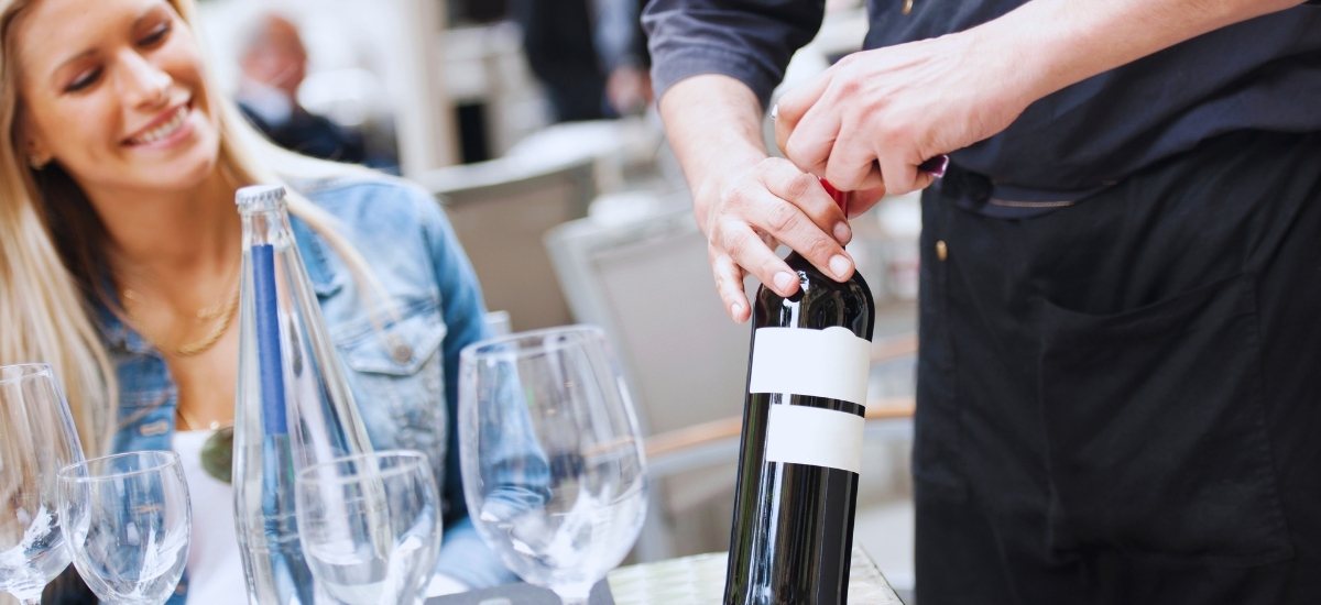 A sommelier presenting a wine recommendation to guests